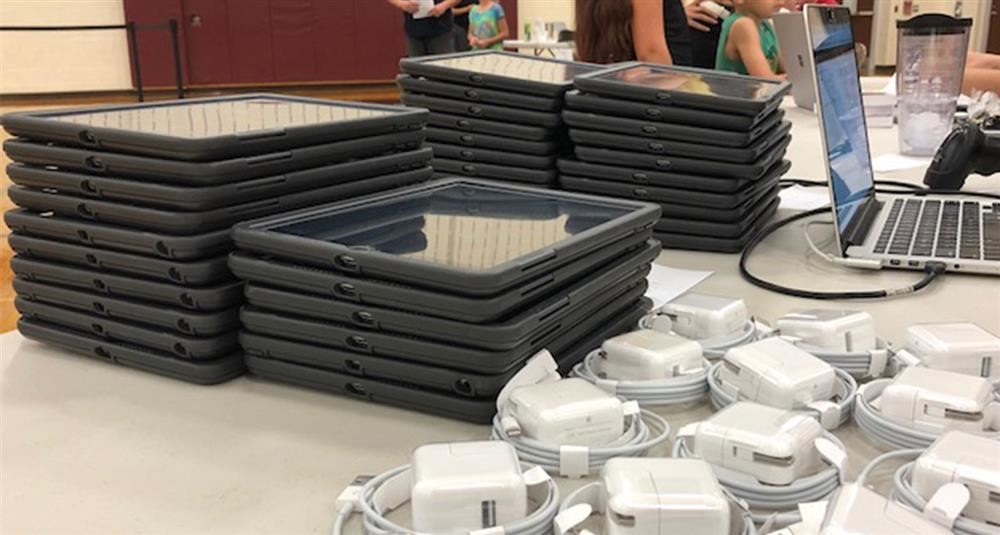A stack of iPads and chargers. A stack of iPads and chargers.